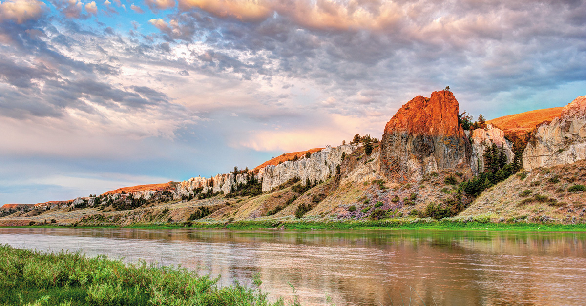 bright cloudy sky over mountains and a river