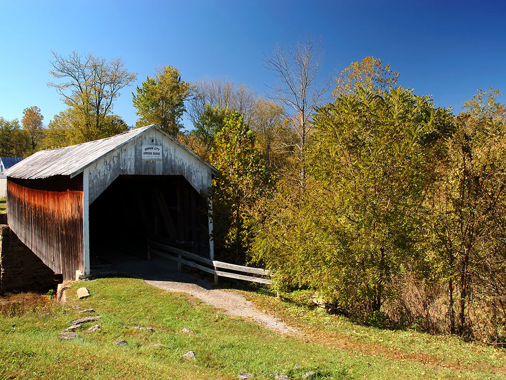 covered bridge in kentucky with blue sky and trees