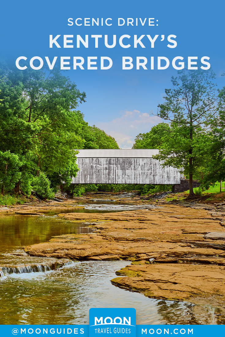 creek with white covered bridge amid green trees in the distance and overlaid text reading kentucky covered bridges