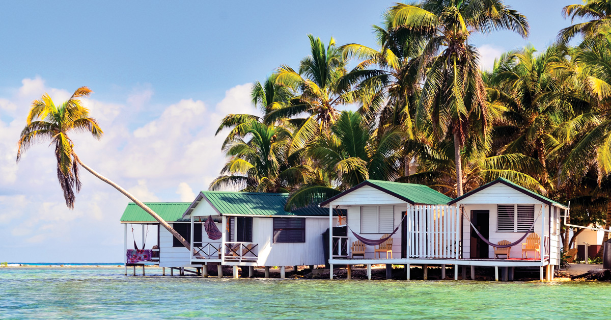 white cabins on an island with palm trees
