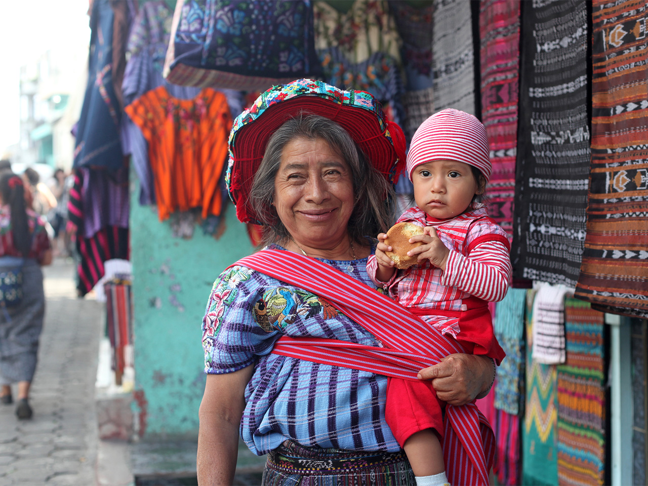 A Maya woman and child in Guatemala smile at the camera.