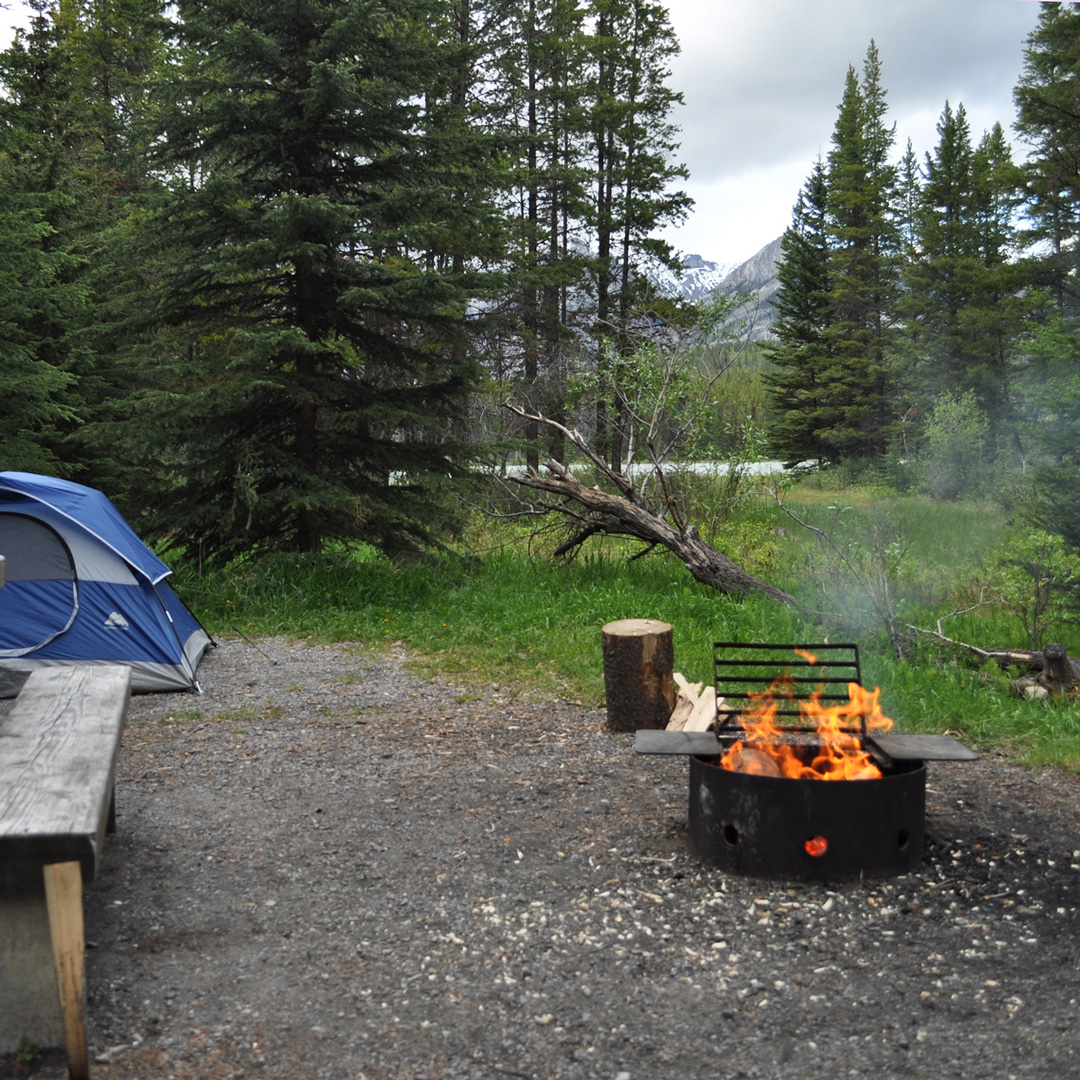 wood burning and tent at campsite in Banff