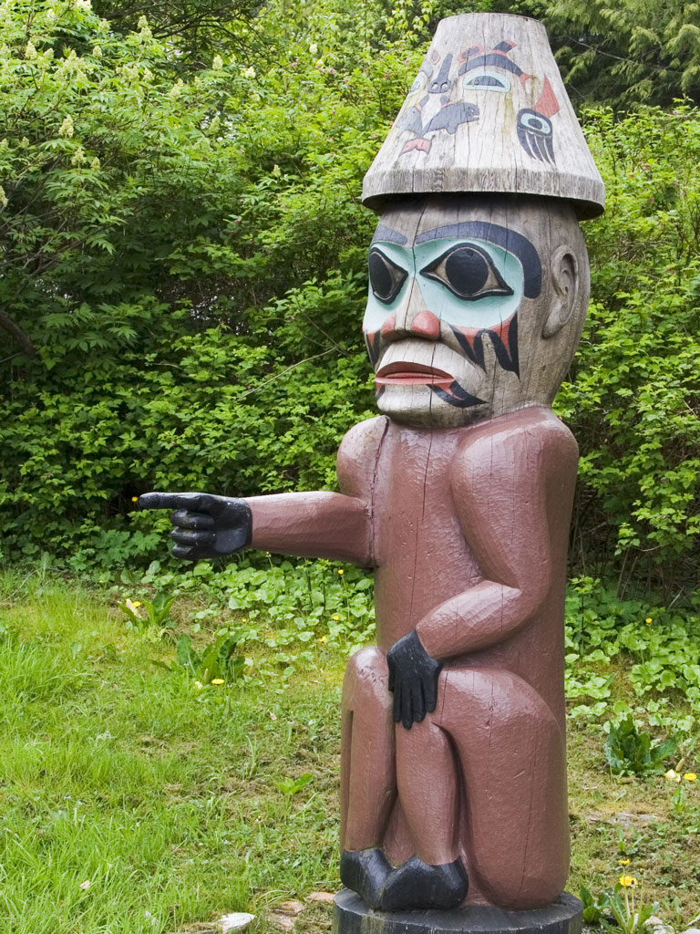 a totem pole figure pointing