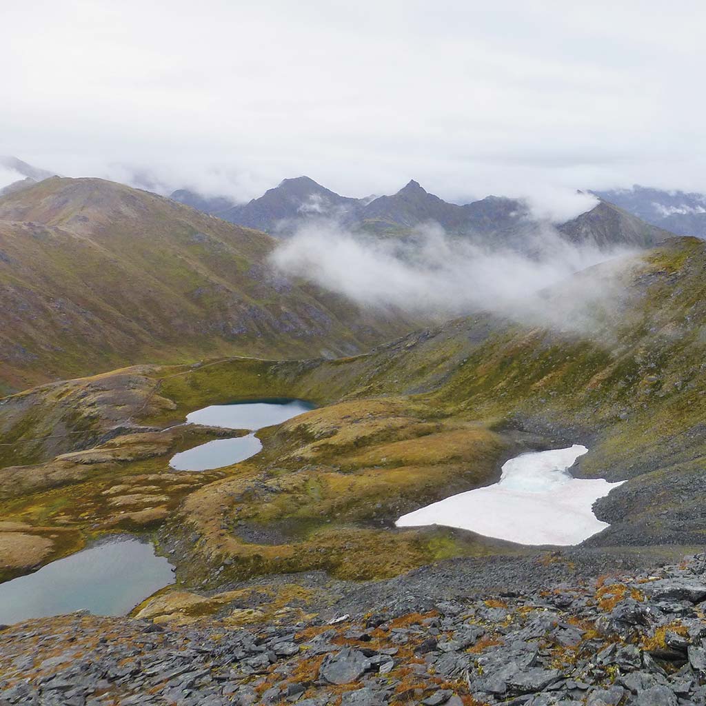 View of Hatcher Pass featuring grass, four small lakes, and some low clouds