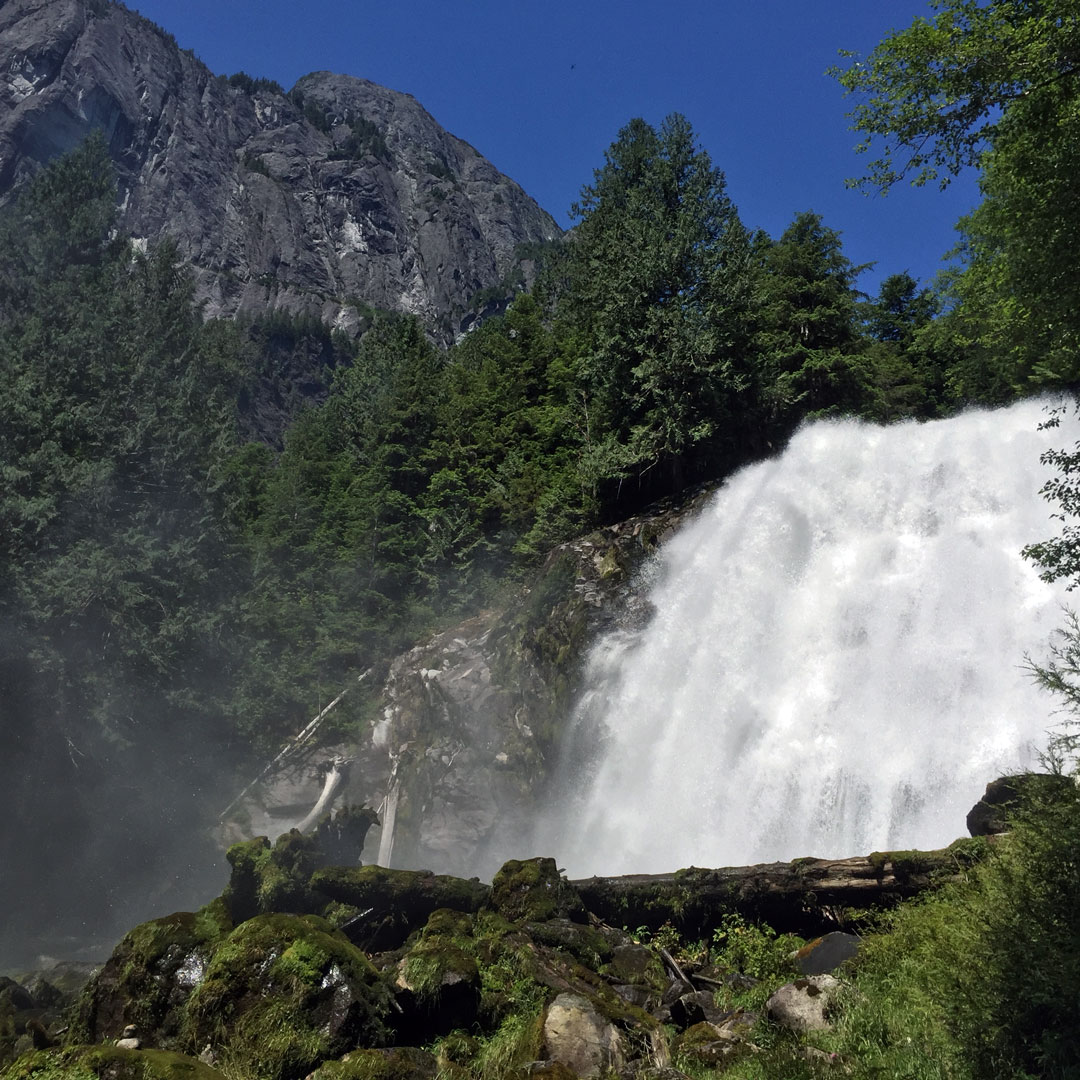 rushing waterfall with a mountainous backdrop