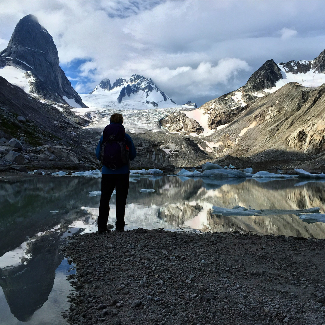 hiker standing near a lake in the Bugaboos of British Columbia