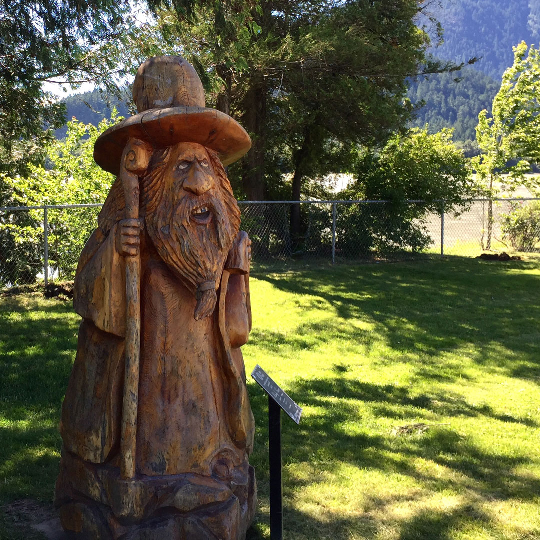 wizard carved in wood sitting on grass