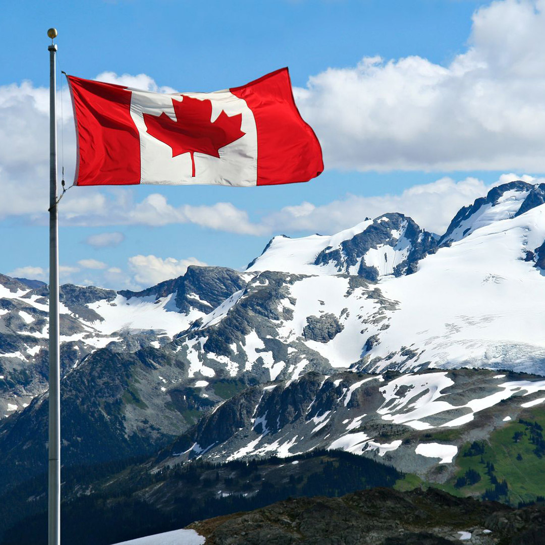 Canadian flag flying over snowy peaks in Whistler