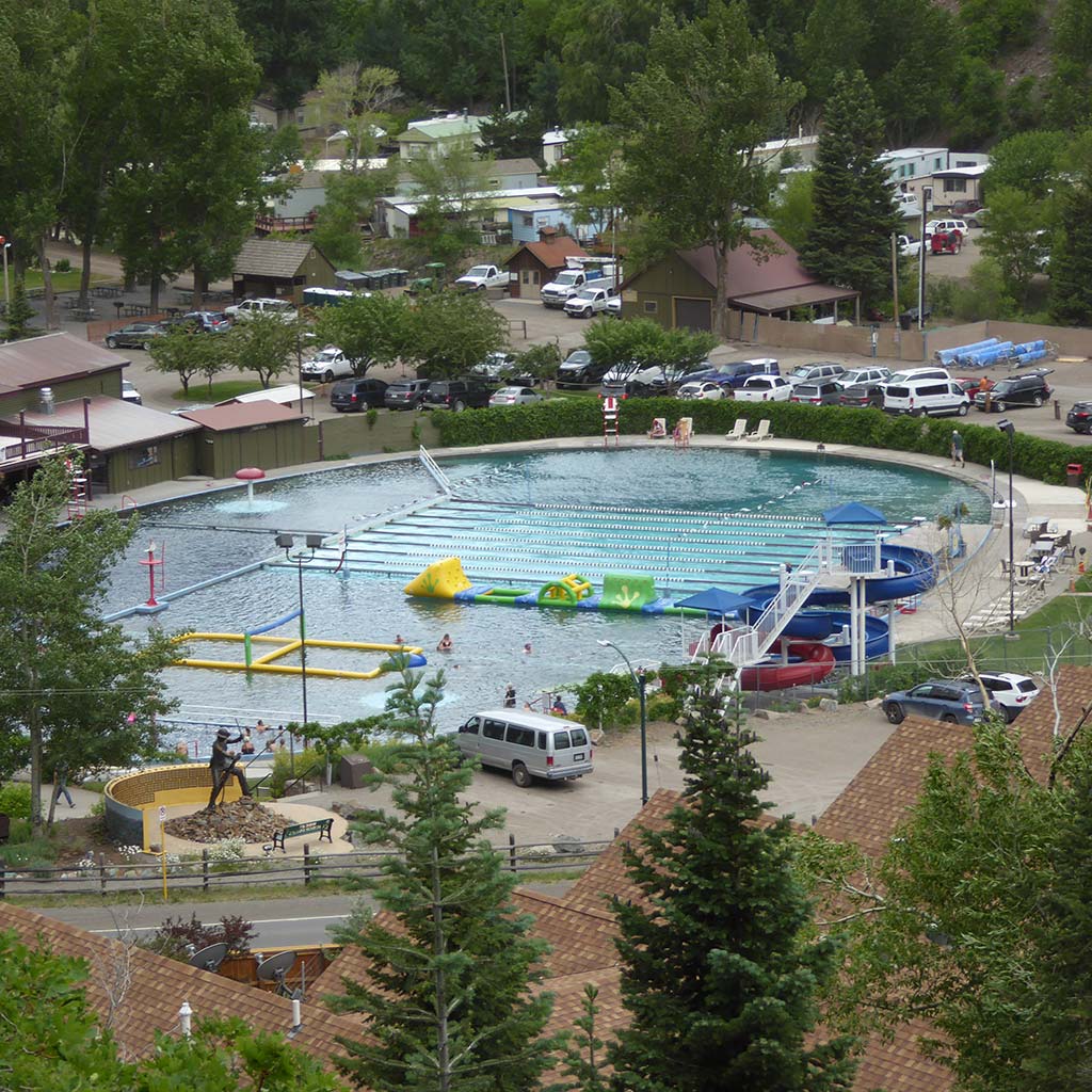 Ouray hot springs is pictured: it looks like a roundish pool and is divided into three sections, one of which has equipment for kids to play on