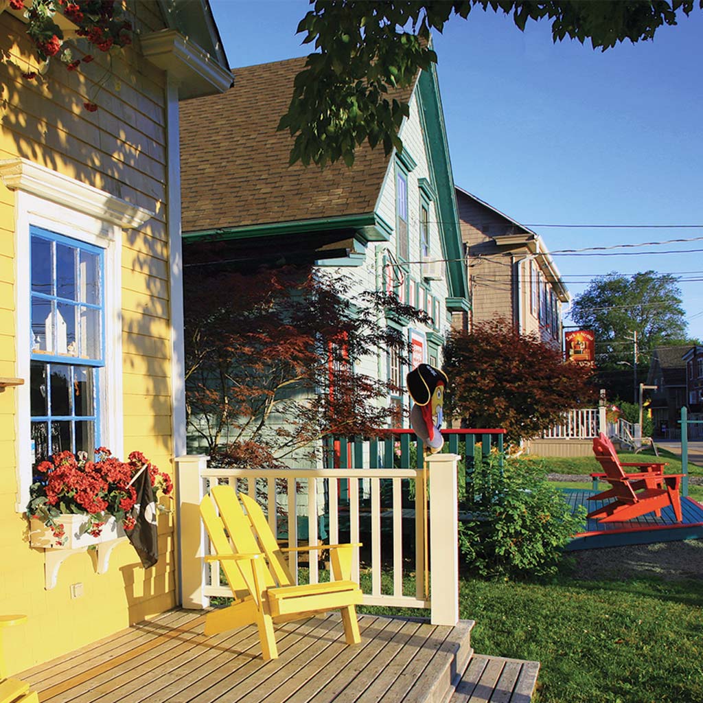 yellow adirondack chair sitting on the deck of a colorful building