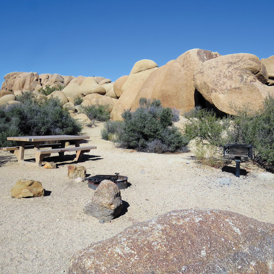 campsite with large rocks surrounding it in the desert