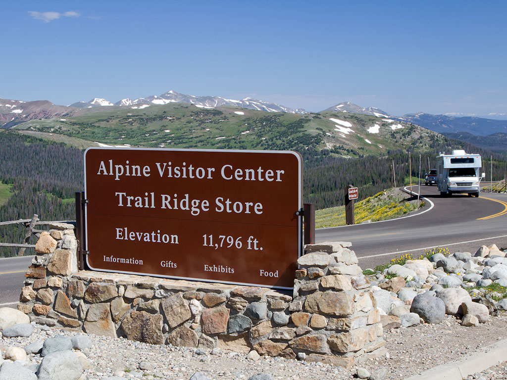 Alpine Visitor Center sign next to a winding road