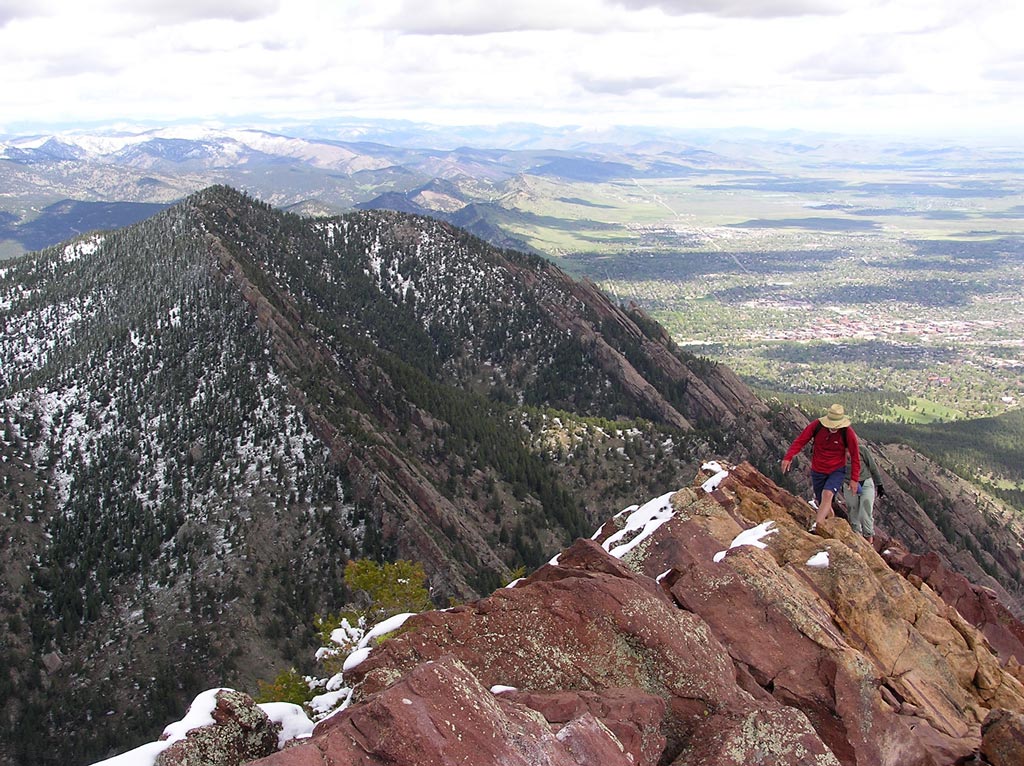 hiker in red climbing bear peak summit in Colorado