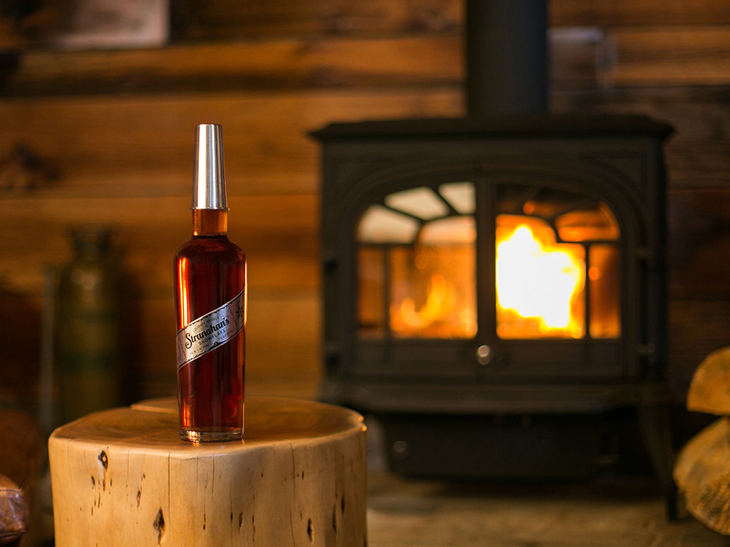 bottle of snowflake whiskey from Stranahans by the fire