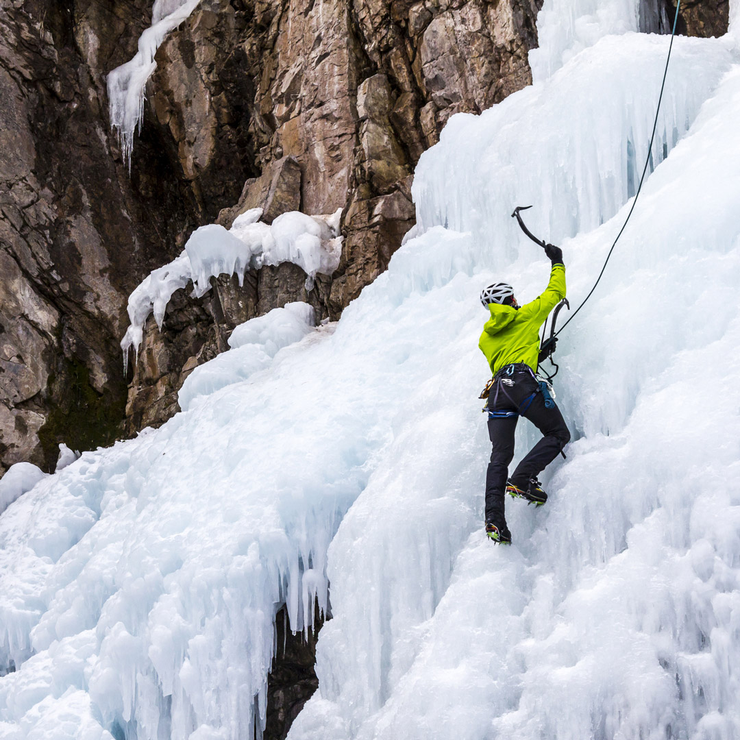 man ice climbing frozen falls in Colorado 