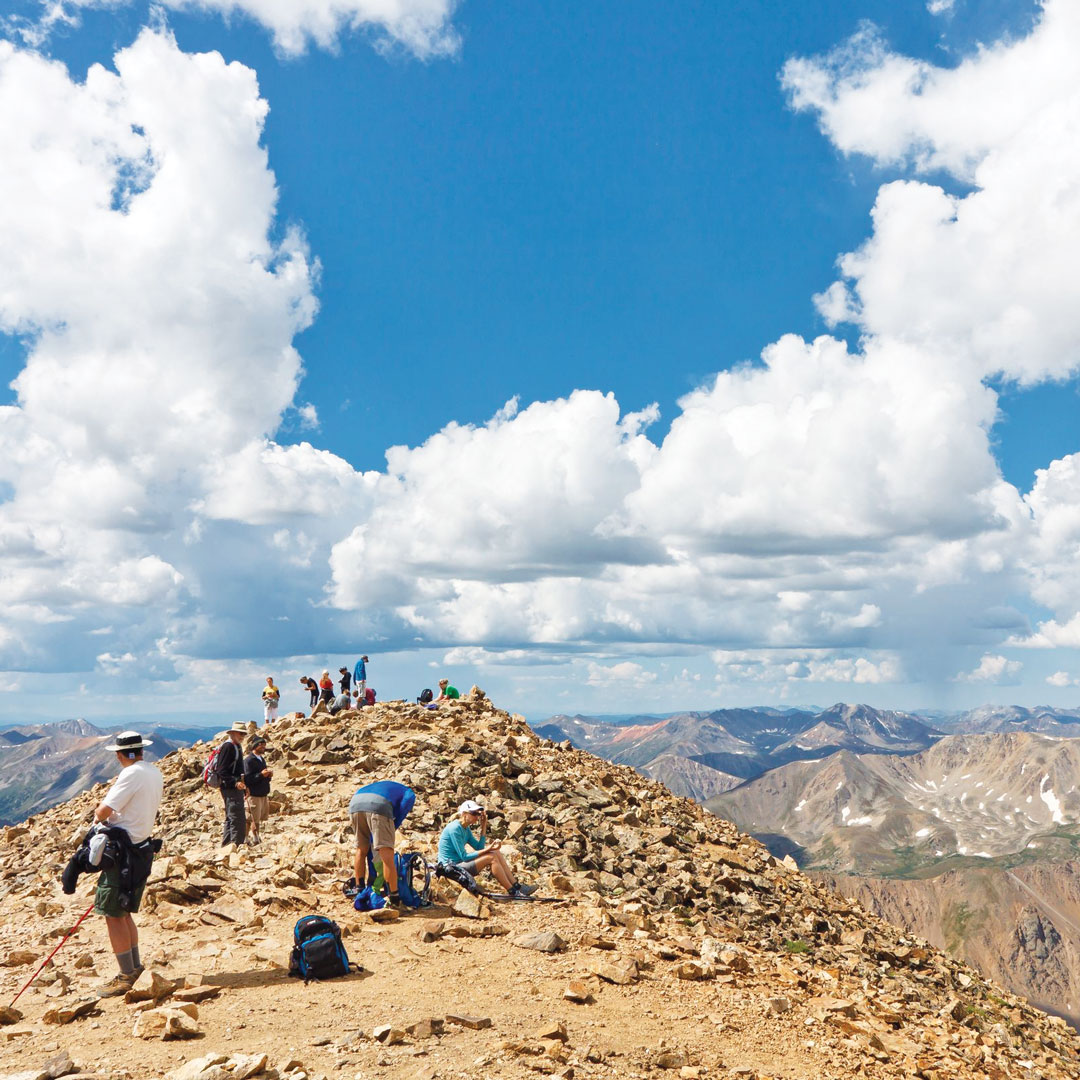 hikers atop the peak of Mount Elbert