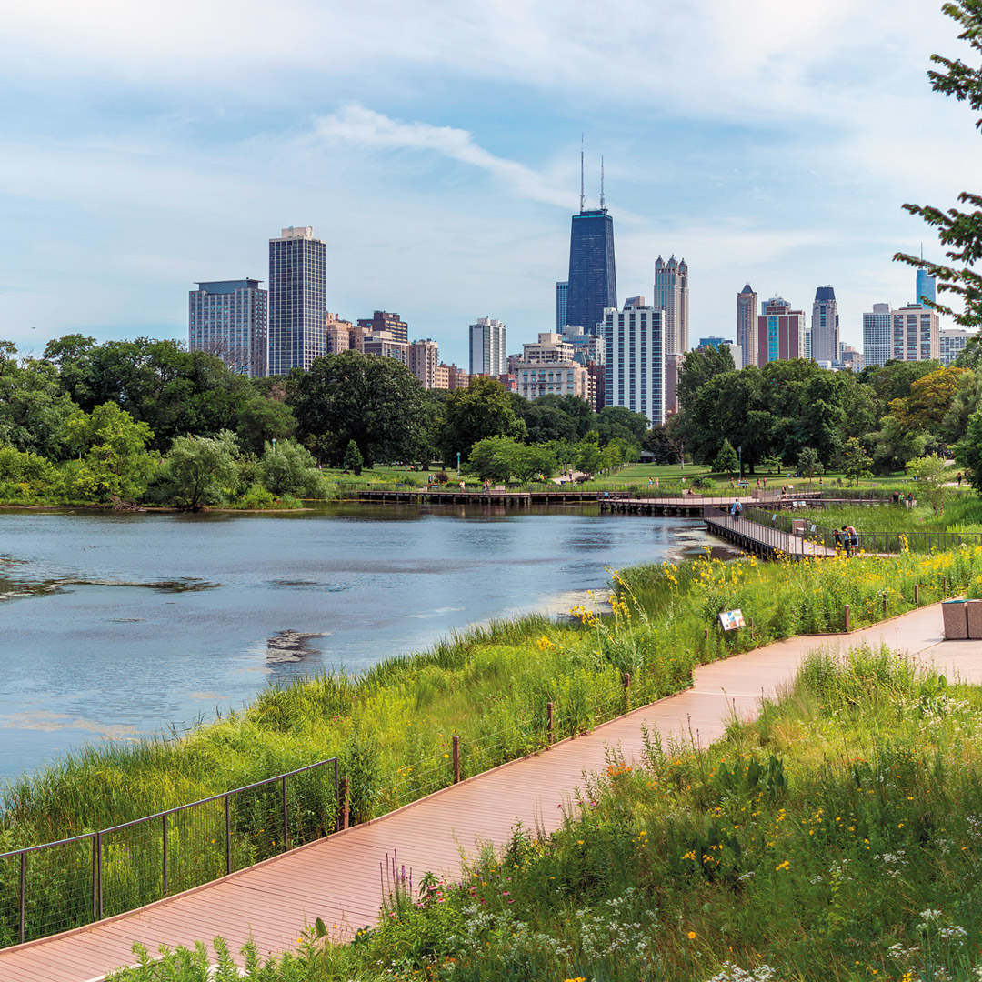 walkway alongside the water in a park with a view of the Chicago skyline
