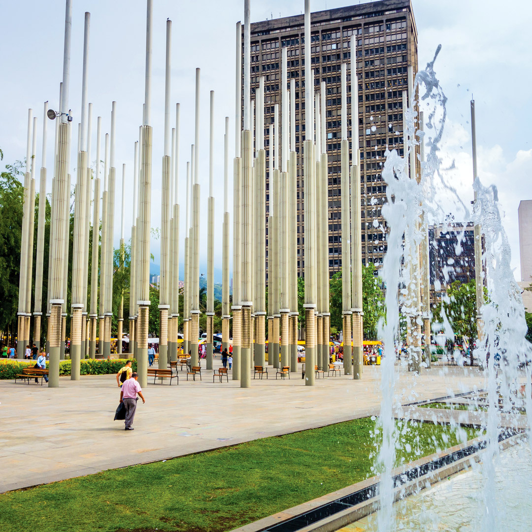 a fountain flowing in front of the spires of Parque de las Luces in Medellin
