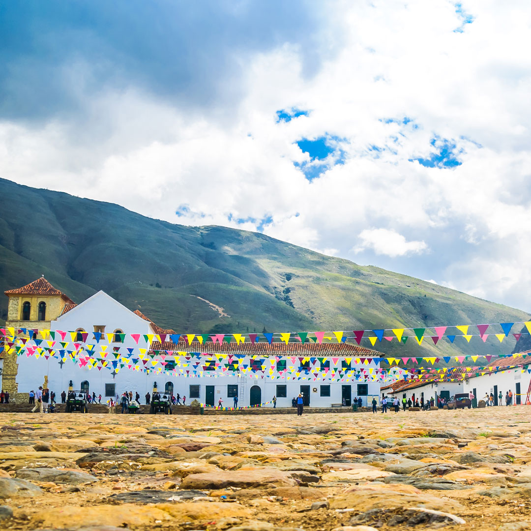 colorful flags surround colonial buildings in Villa de Leyva's central plaza