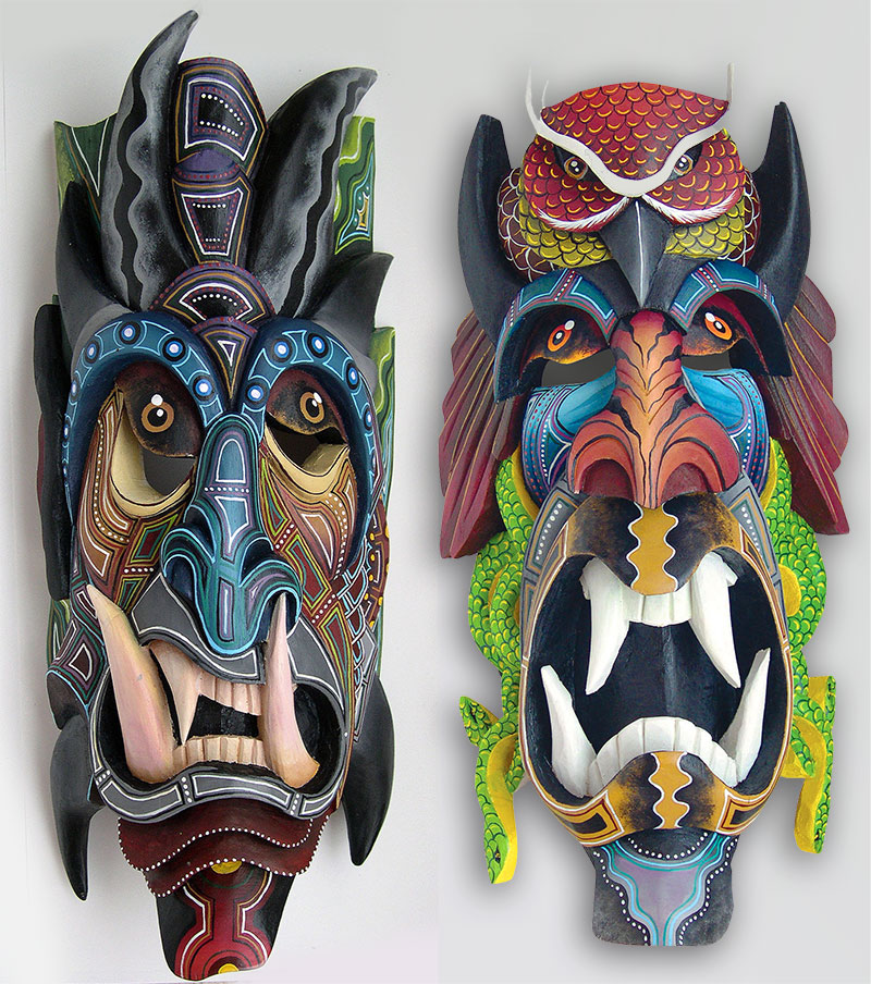 A pair of colorful and intricately carved Boruca masks with large teeth and devilish features.