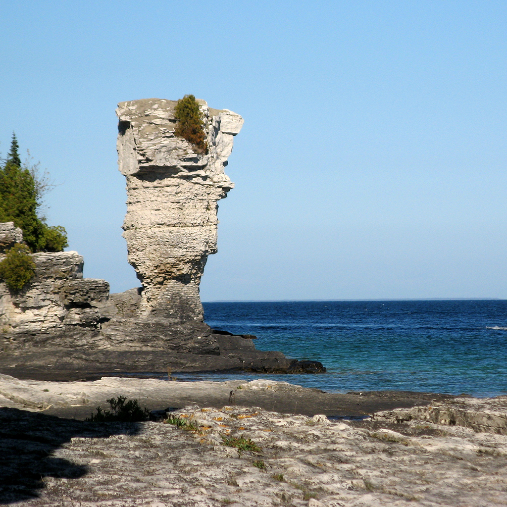 A rocky island is pictured with a towering rock structure