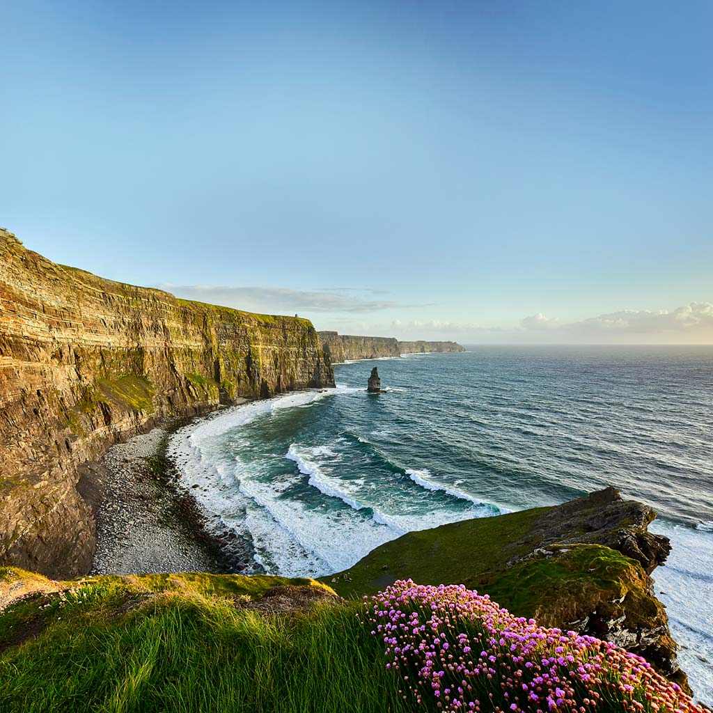 View down the Cliffs of Moher with the waves rolling in.