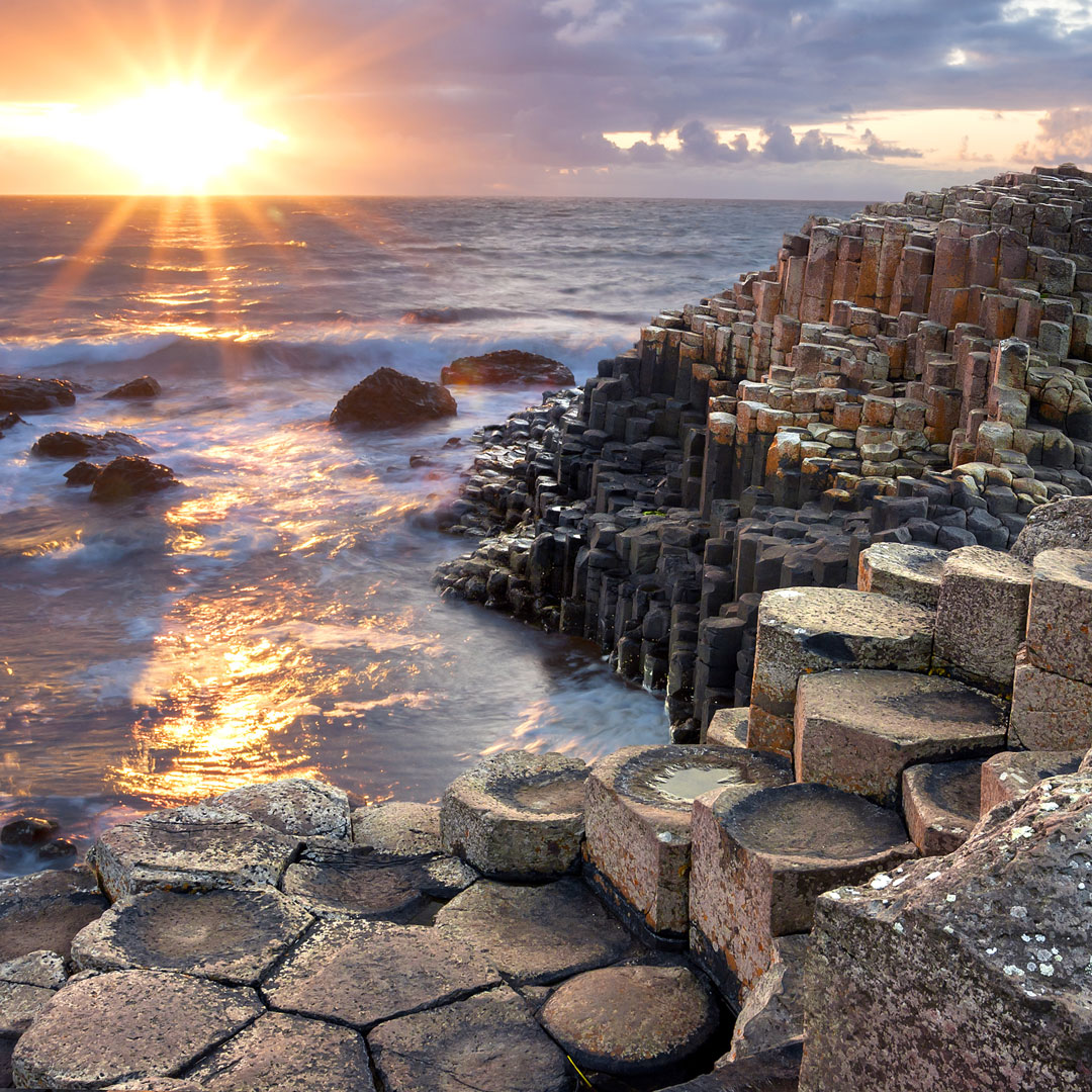 purple hues of sunset over the coastal area of Giant's Causeway in Ireland