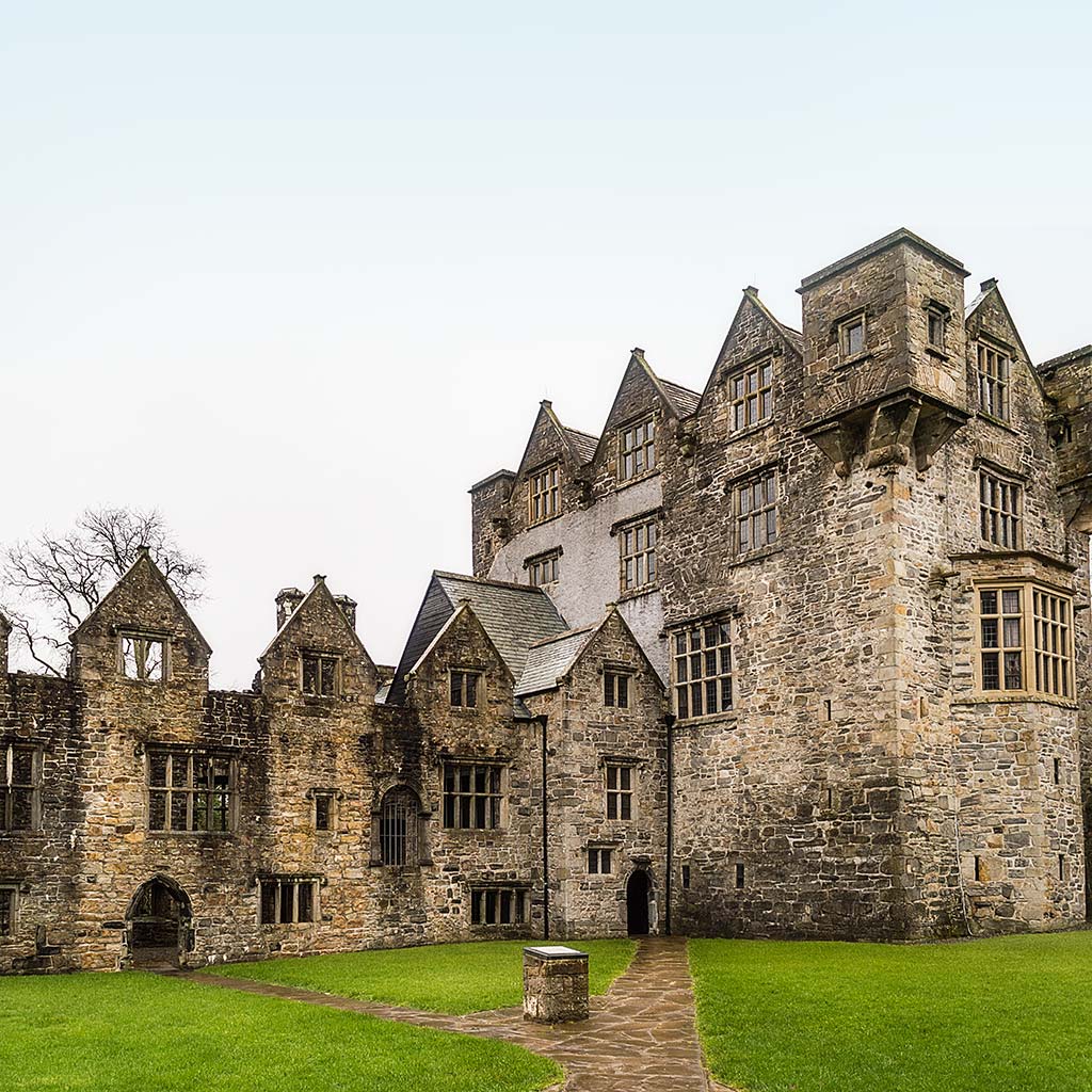 Amidst the walls of Donegal Castle, a stone walkway cuts through a low lawn.