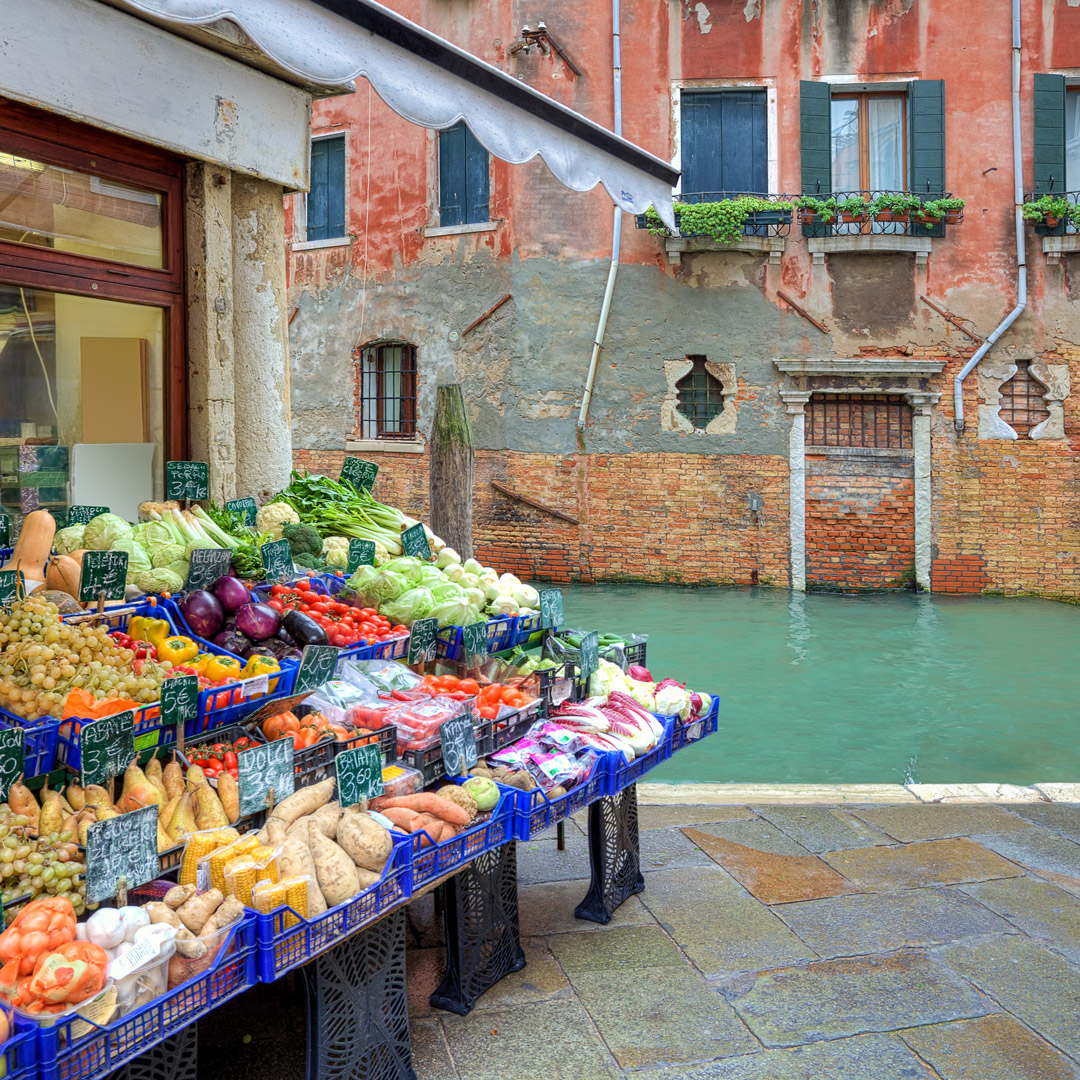 fresh vegetables for sale in front of a small market in Venice