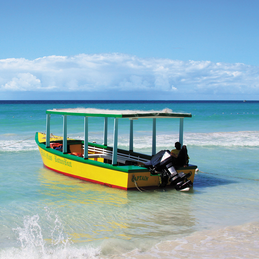 a yellow boat along the shore of Seven Mile Beach in Jamaica