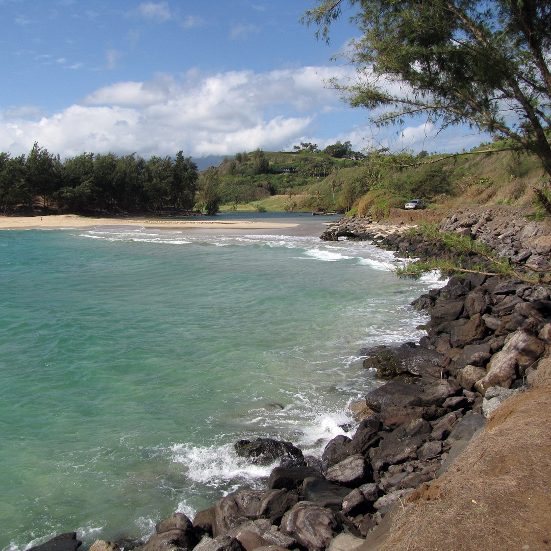 view of kahili beach with the ocean crashing onto the rocks