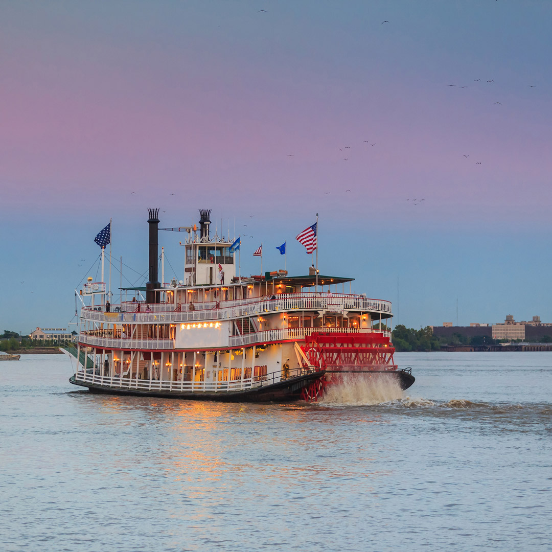 steamboat sailing on the Mississippi River during sunset in New Orleans