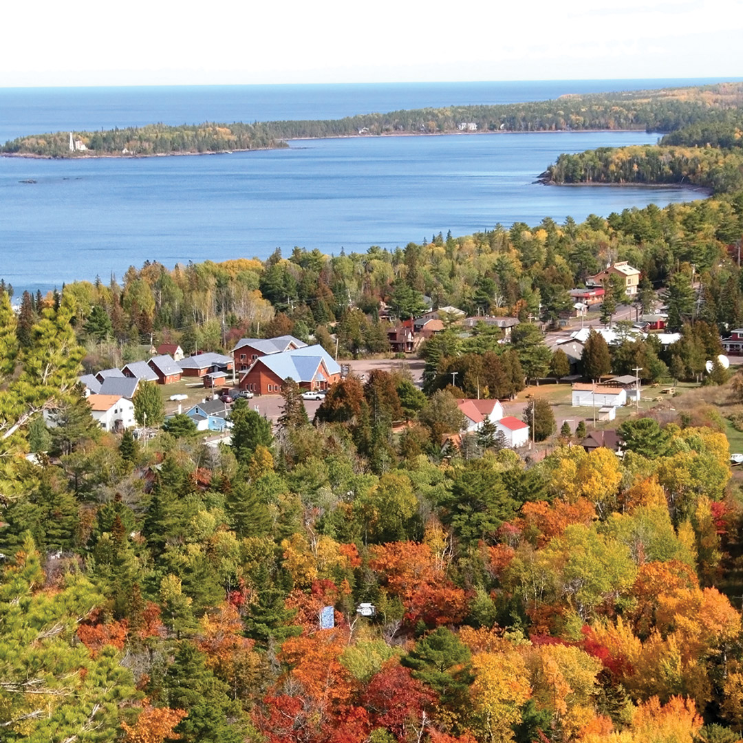red, orange, and yellow trees surround the lake in Copper Harbor