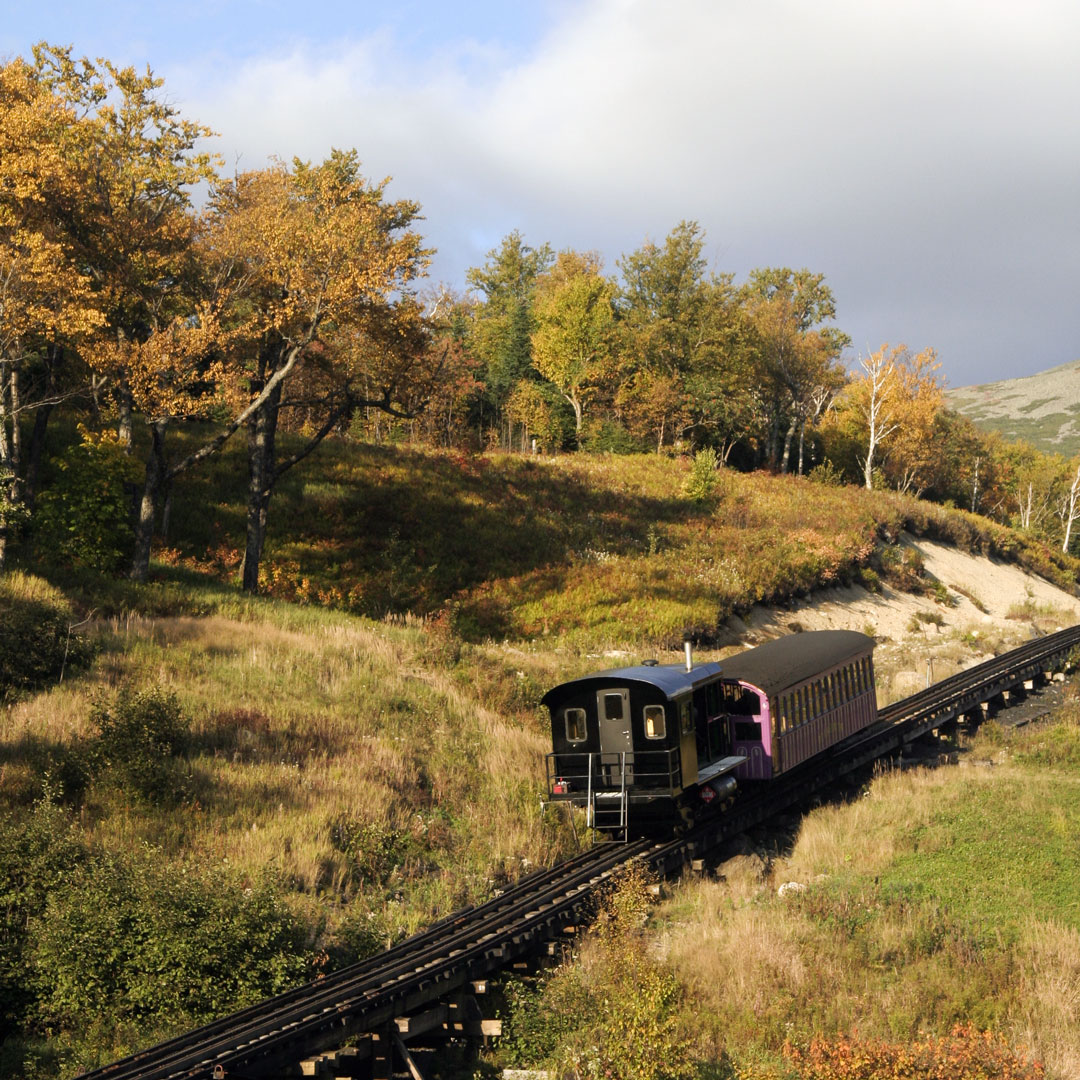 train chugging through fall color in New Hampshire