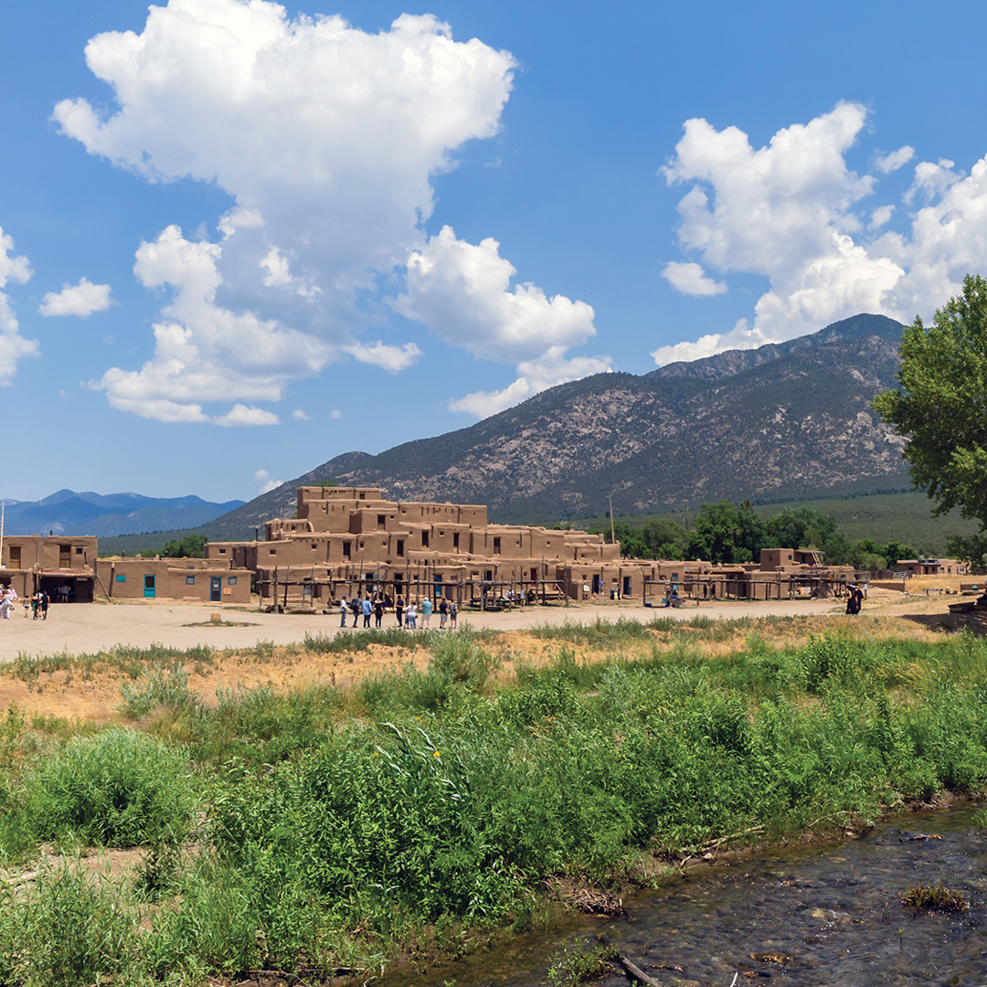 puebloan structures sit among the mountains and landscape of Taos