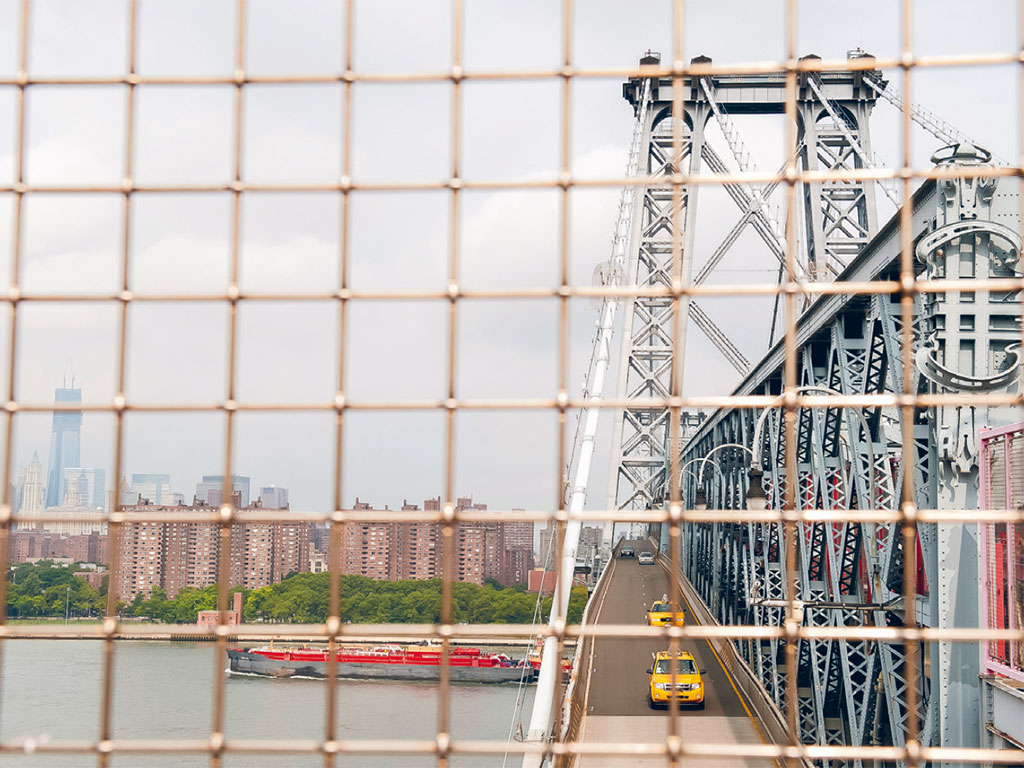 view through a fence on the Williamsburg Bridge of the Brooklyn skyline