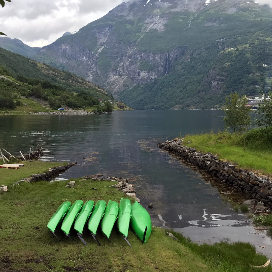 bright green kayaks on the shore near Geirangerfjord in Norway