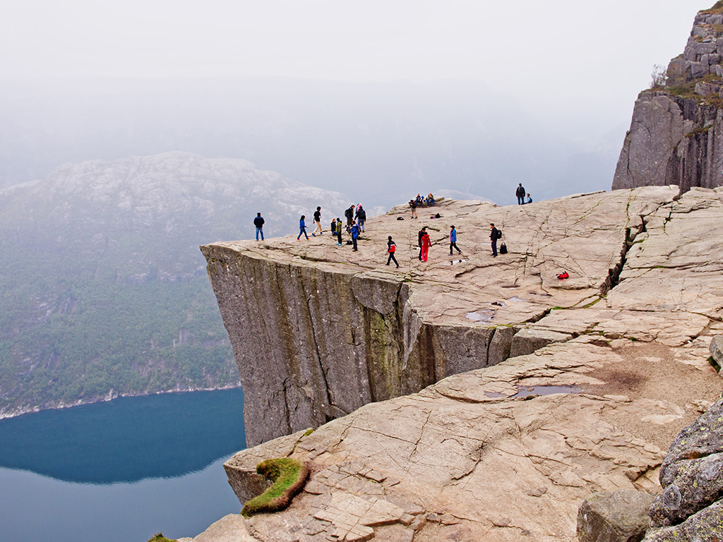 tourists gather atop Preikestolen after the infamous Pulpit Rock hike