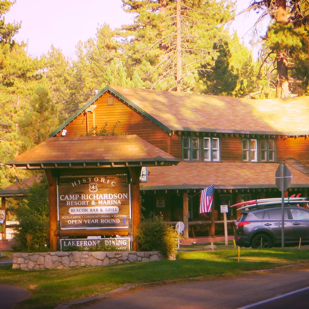 a cabin in the woods dappled with sun shining through trees