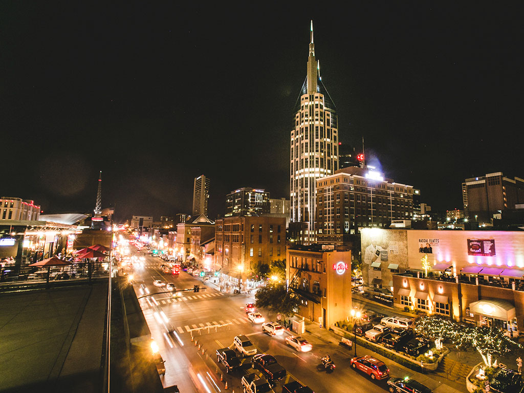 view of Broadway Street in Nashville at night from a rooftop bar