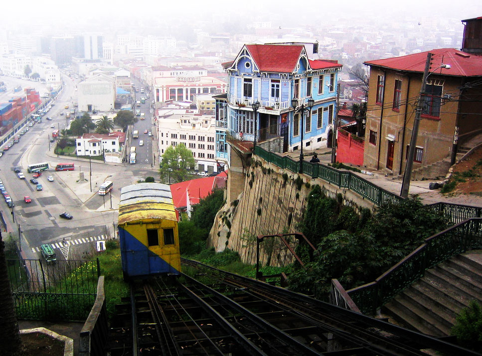 A funicular descends on its track beside a colorful hillside neighborhood.