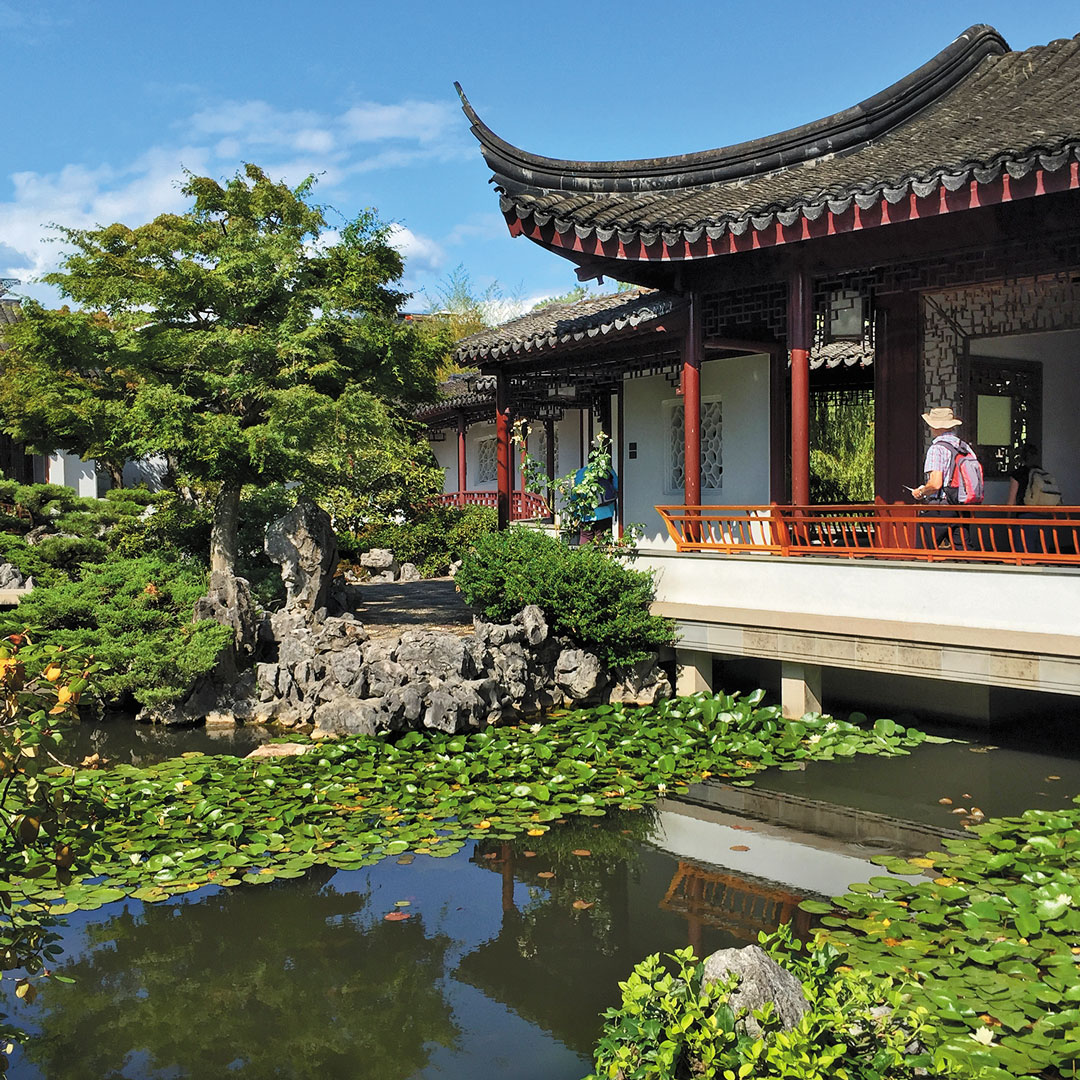 a pond in front of a traditional Chinese building