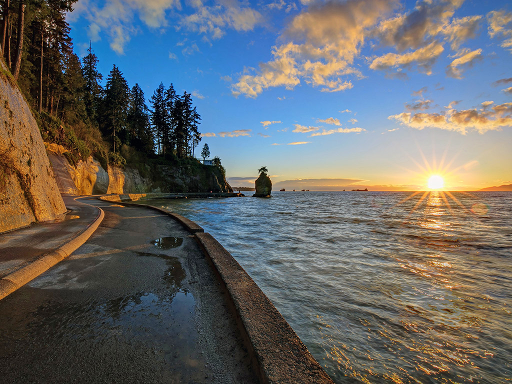 sunset on the water by the Stanley Park Seawall promenade in Vancouver