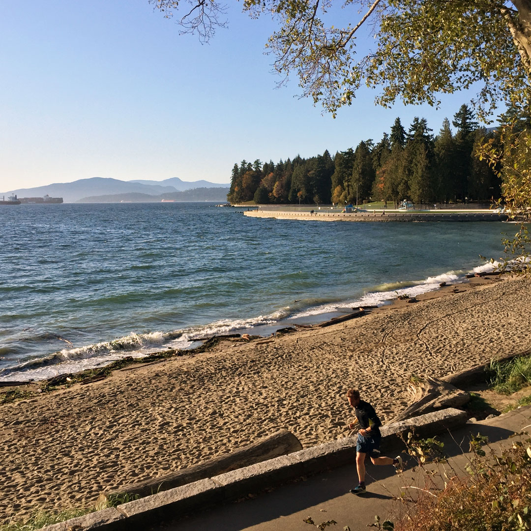 man running on the path along Stanley Park Seawall