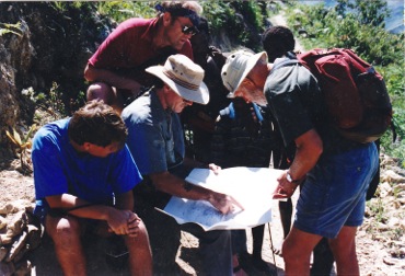 A tour group huddles around a guide with a map.