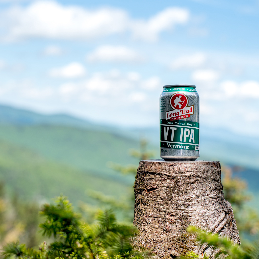 a beer can sitting on a tree stump