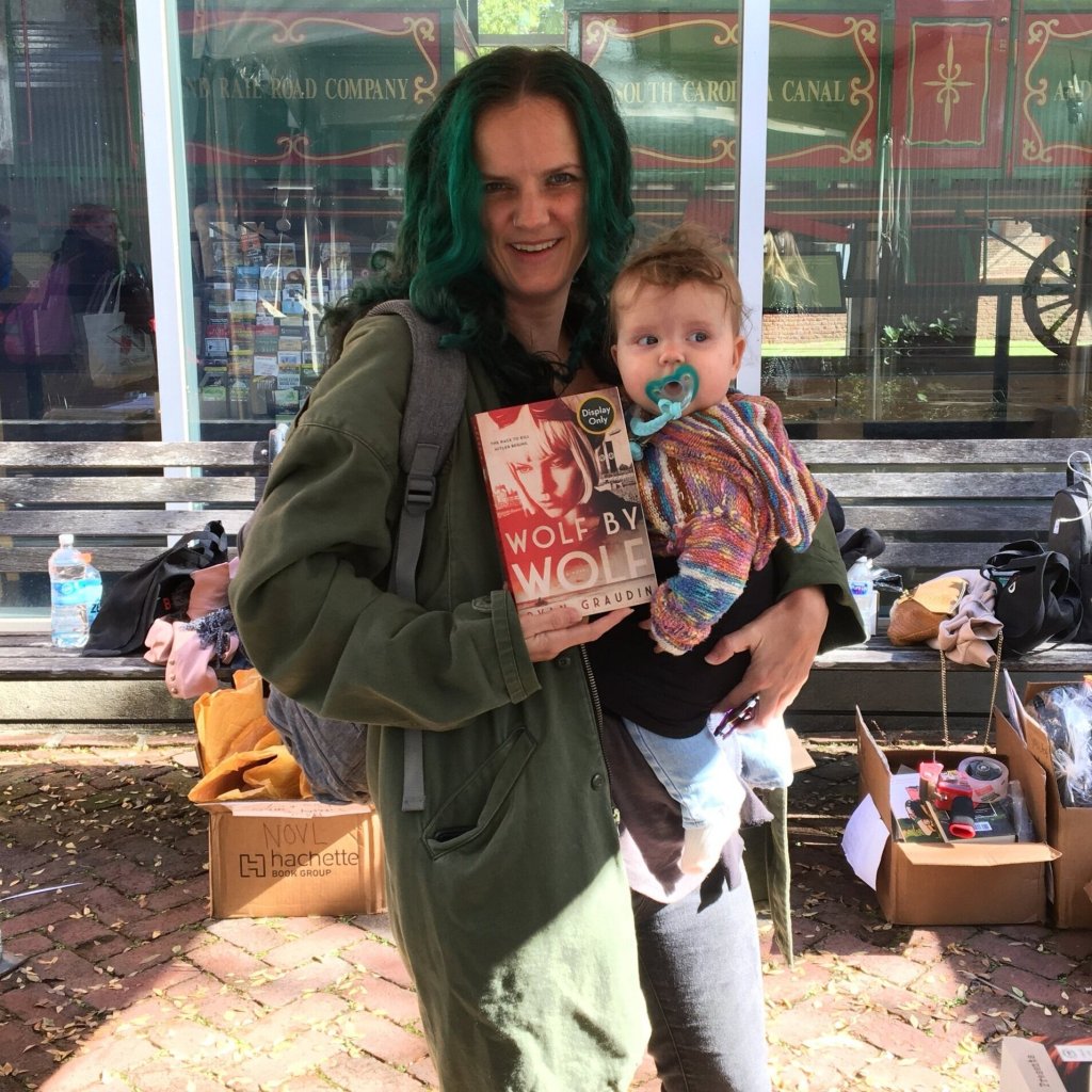 NOVL - Image of Ryan Graudin holding up her book 'Wolf by Wolf' at YALLFest