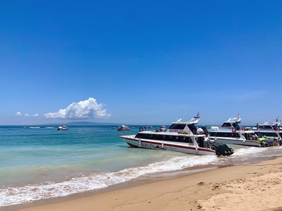 speed boats docked on a shoreline of a beach