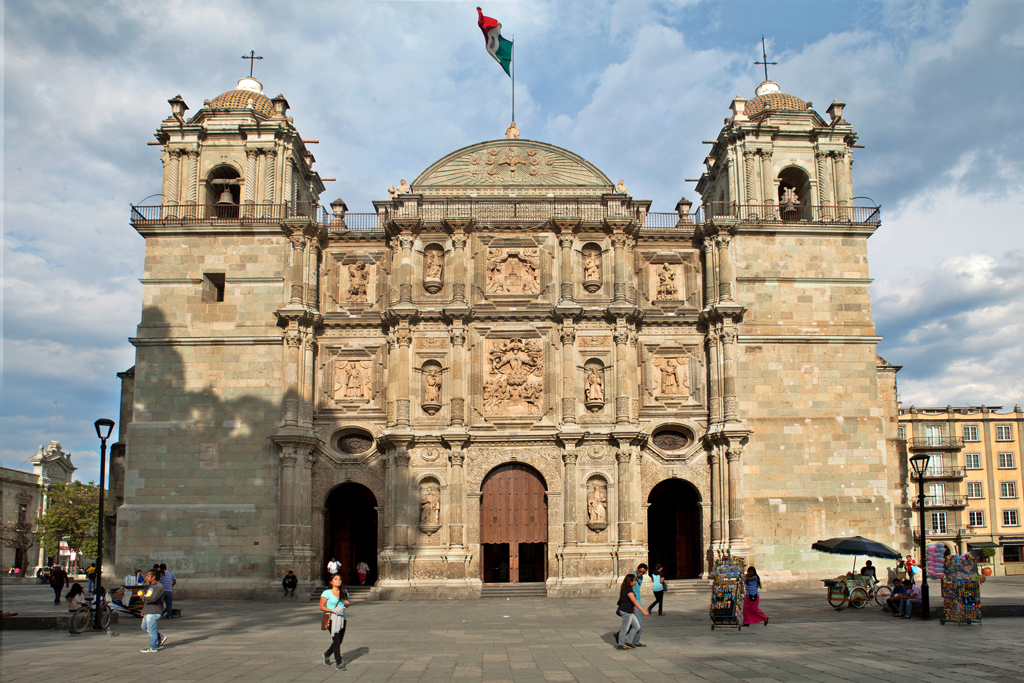 Image of a church at the Zocalo in Oaxaca with the Mexican Flag Flowing