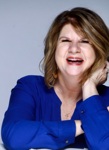 author photo of woman author laughing in blue shirt